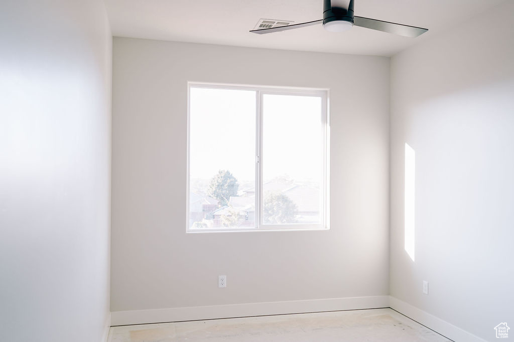 Unfurnished room featuring plenty of natural light and ceiling fan