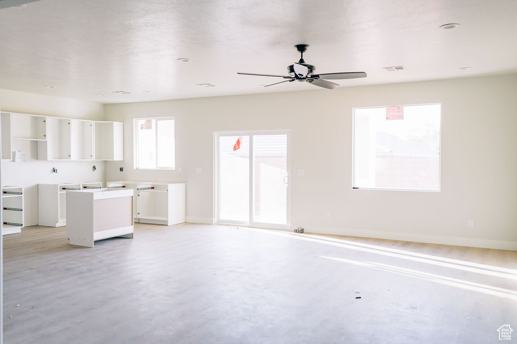 Unfurnished living room featuring ceiling fan and light hardwood / wood-style flooring