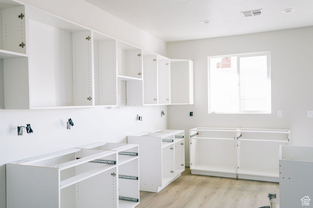 Laundry room with light hardwood / wood-style floors