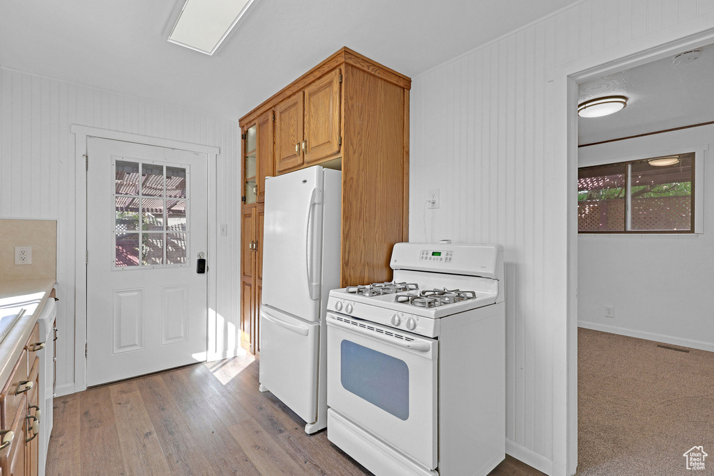 Kitchen featuring white appliances and light wood-type flooring