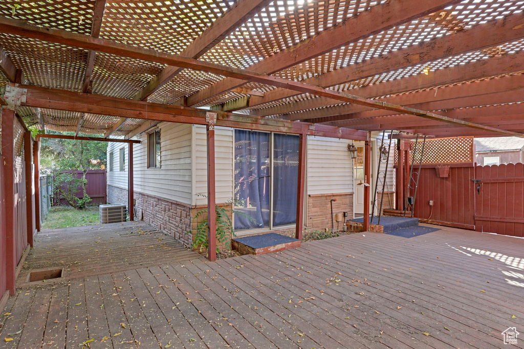 Wooden deck featuring a pergola and cooling unit