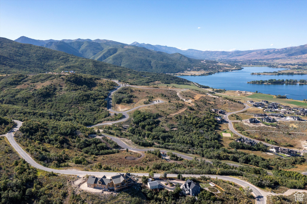 Birds eye view of property with a water and mountain view