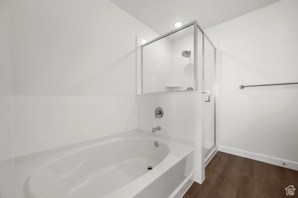 Bathroom featuring wood-type flooring and shower with separate bathtub