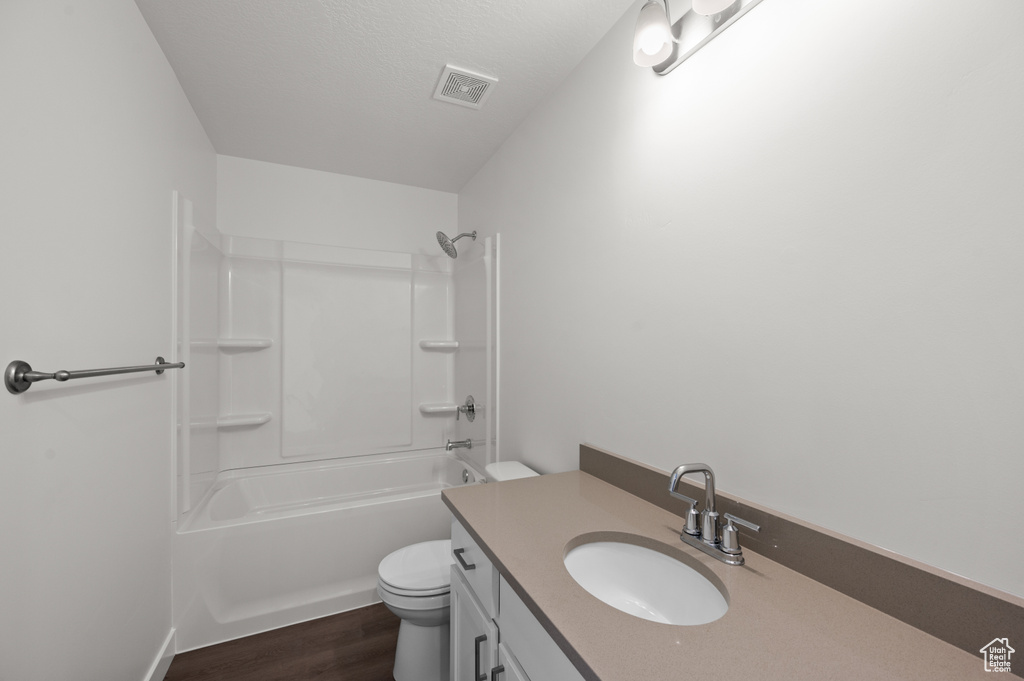 Full bathroom with shower / bath combination, hardwood / wood-style flooring, vanity, and toilet