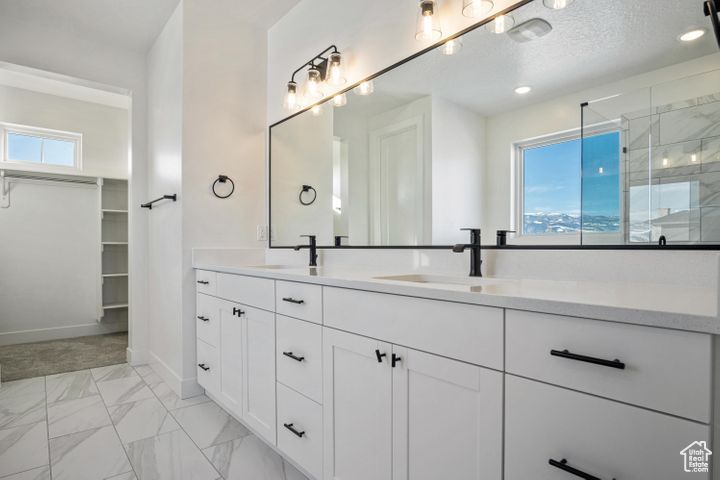 Bathroom featuring a textured ceiling, vanity, plenty of natural light, and an enclosed shower