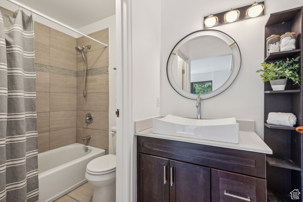 Full bathroom featuring vanity, toilet, tile patterned floors, and shower / tub combo with curtain