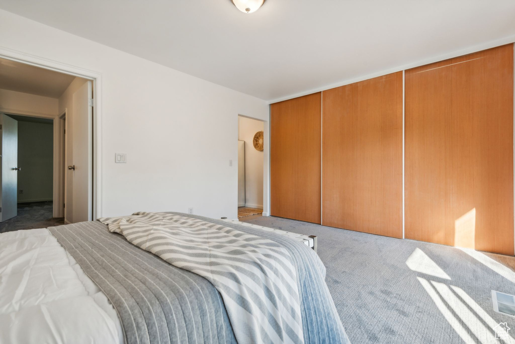 Bedroom featuring light carpet and a closet