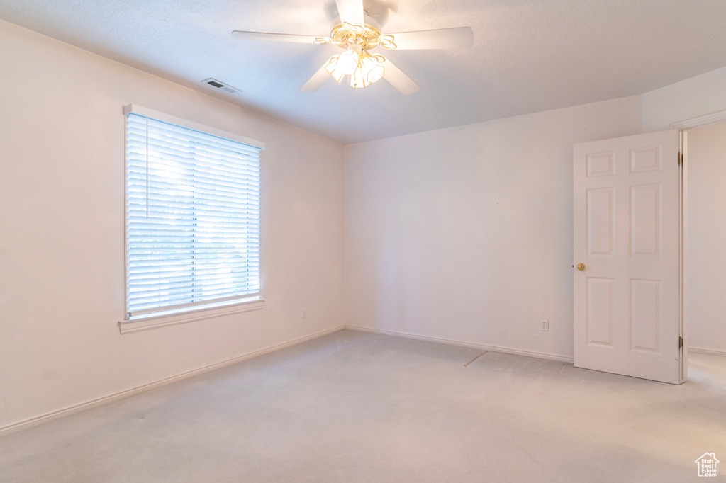 Spare room featuring ceiling fan and light colored carpet