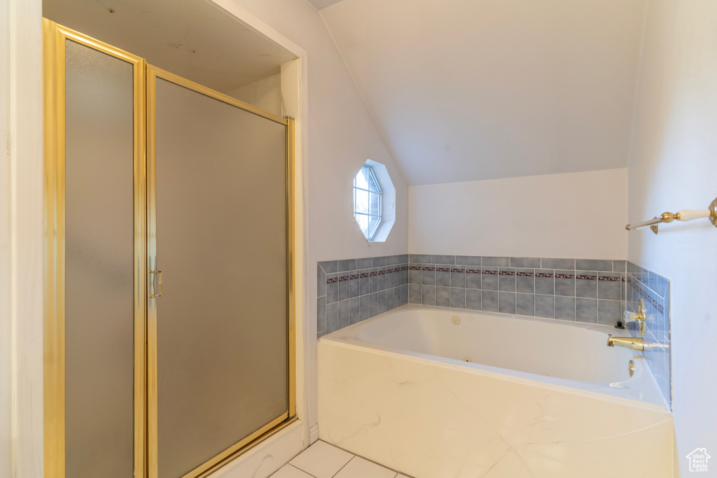 Bathroom featuring lofted ceiling, tile patterned floors, and separate shower and tub