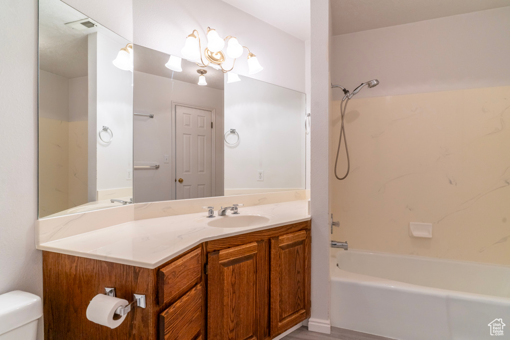 Full bathroom featuring hardwood / wood-style flooring, vanity,  shower combination, and toilet