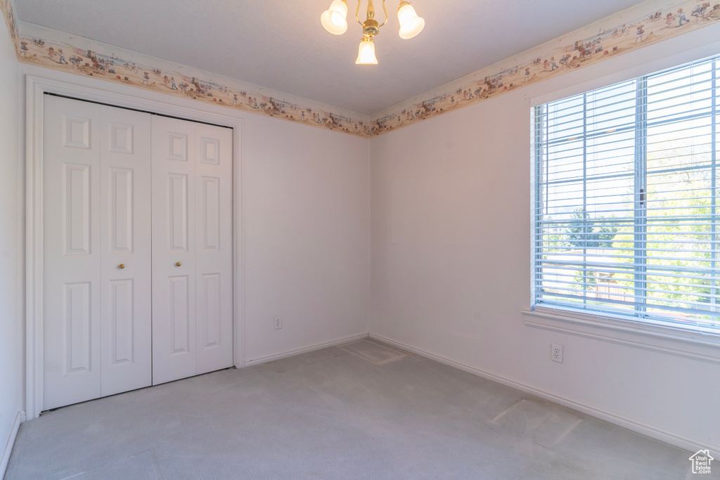 Unfurnished bedroom featuring a closet, carpet, and multiple windows