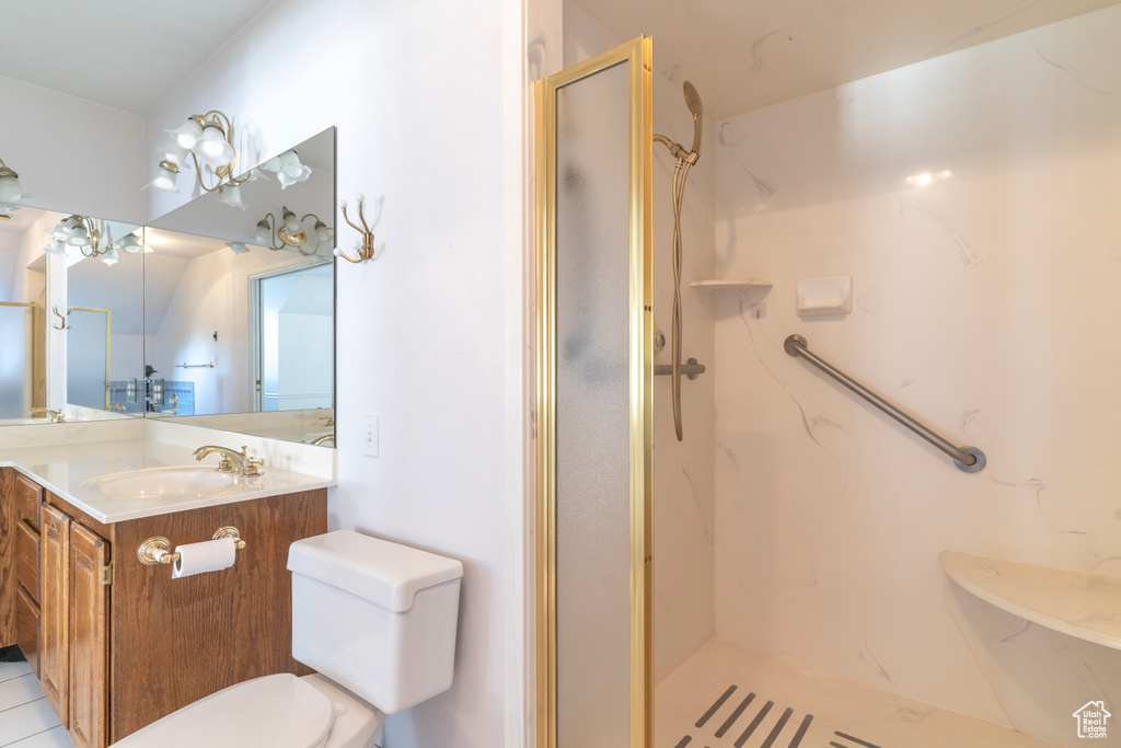 Bathroom featuring walk in shower, vanity, toilet, and tile patterned floors