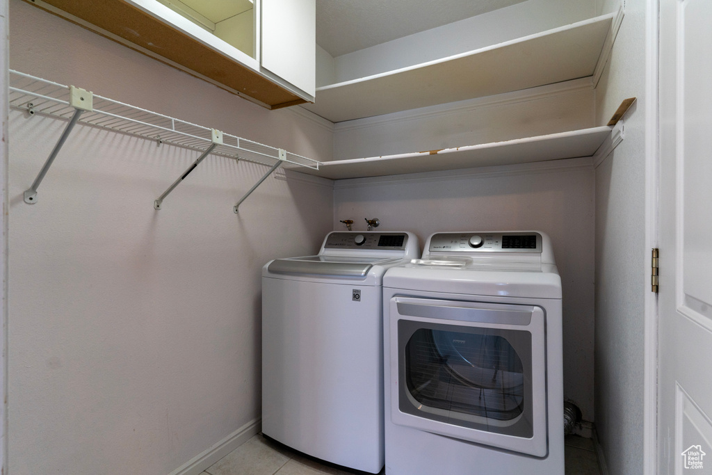 Washroom featuring washer and clothes dryer and light tile patterned floors