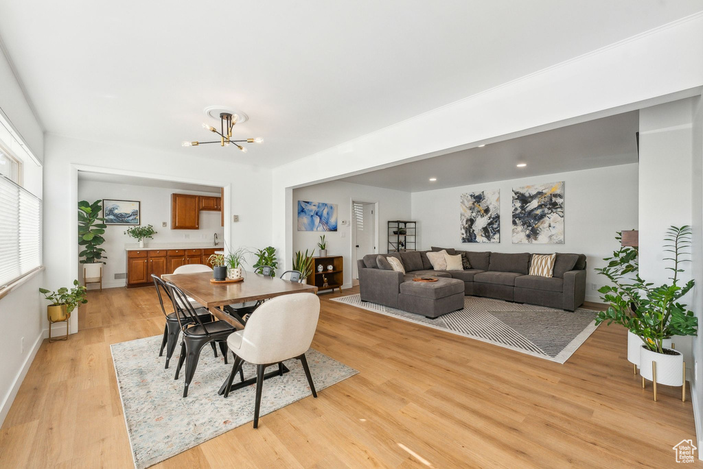 Dining area featuring a notable chandelier and light wood-type flooring