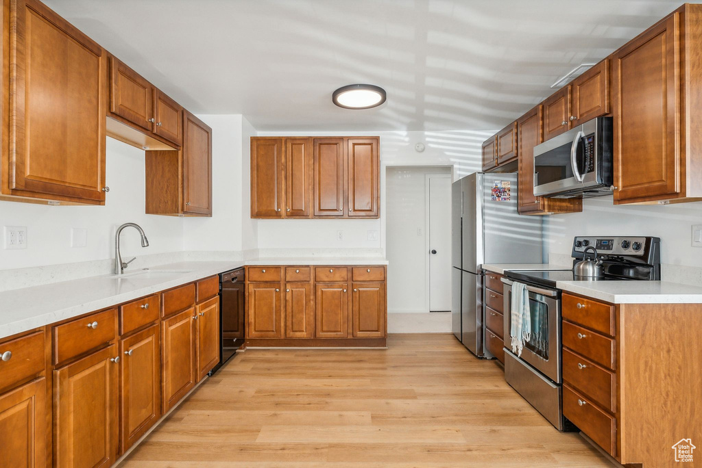 Kitchen featuring sink, light hardwood / wood-style flooring, and stainless steel appliances