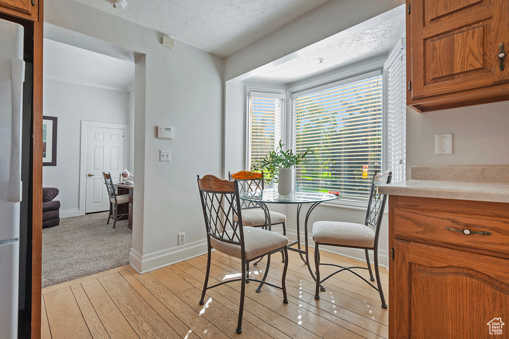 Dining room featuring a textured ceiling and light wood-type flooring