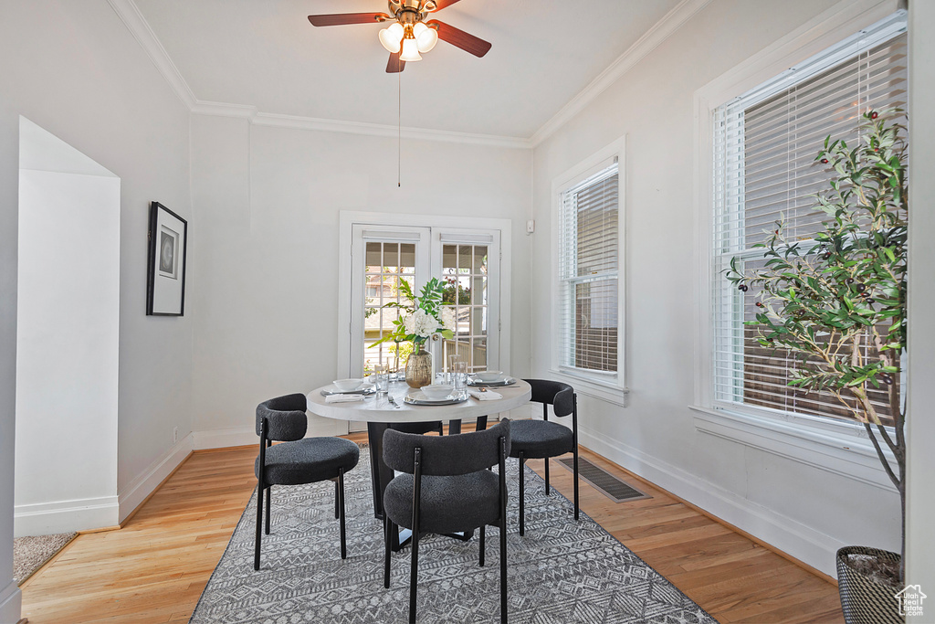 Dining space featuring crown molding, hardwood / wood-style flooring, and ceiling fan