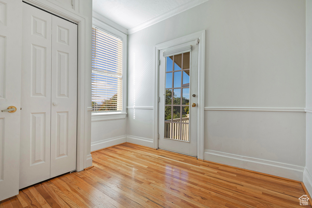 Doorway featuring light hardwood / wood-style floors and crown molding