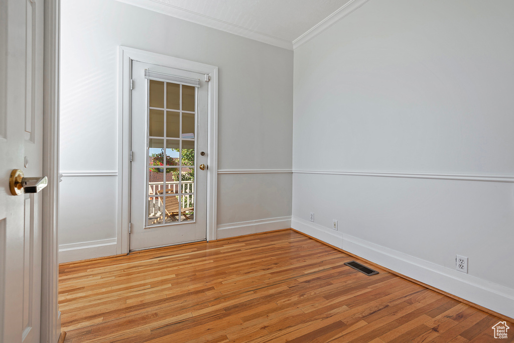 Spare room featuring light hardwood / wood-style floors and crown molding