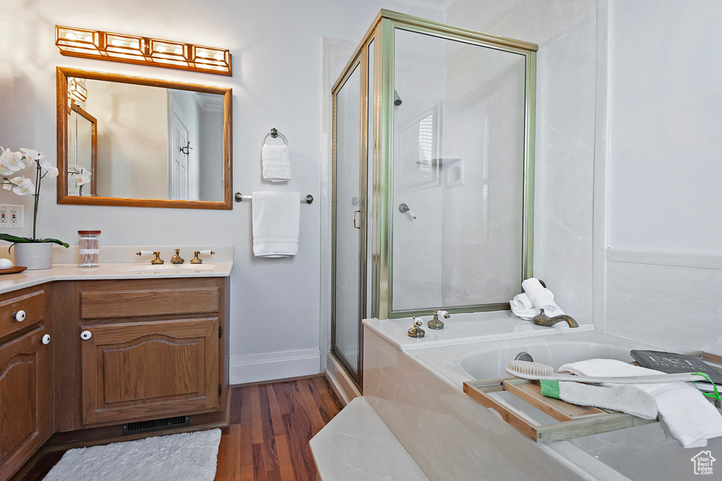 Bathroom with vanity, hardwood / wood-style floors, and plus walk in shower