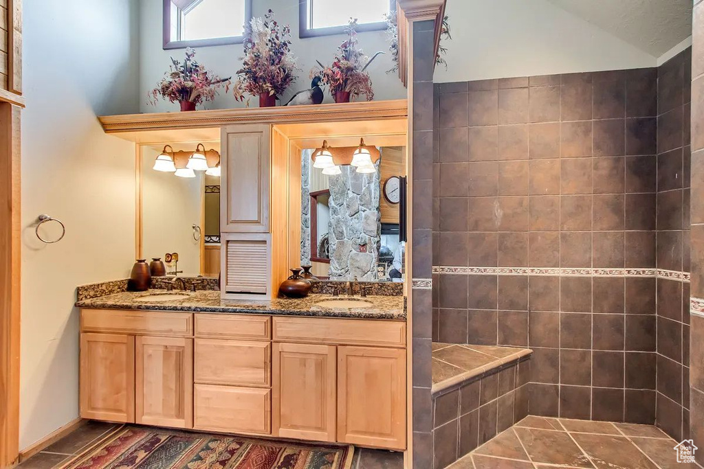 Bathroom featuring vanity, lofted ceiling, and tile patterned flooring