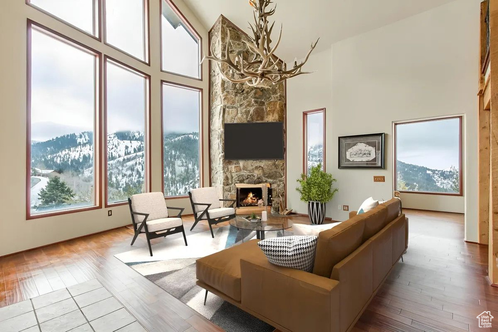 Living room with a high ceiling, light hardwood / wood-style flooring, and a fireplace