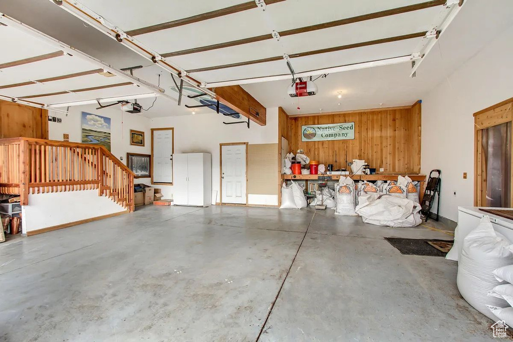 Garage featuring wooden walls and a garage door opener