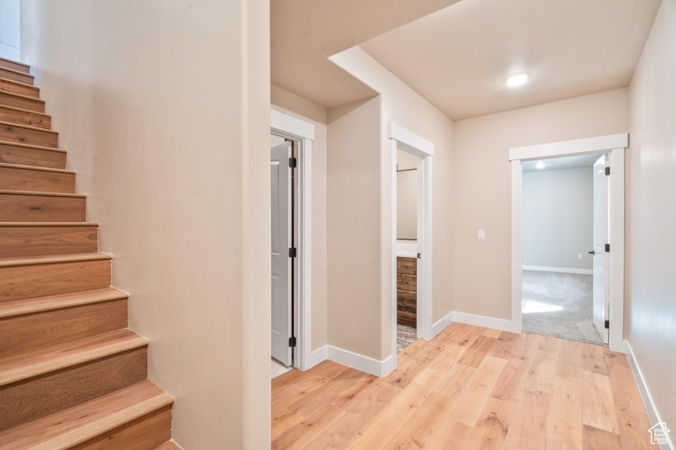 Corridor with light hardwood / wood-style flooring