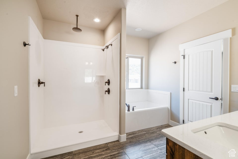 Bathroom featuring vanity, independent shower and bath, and wood-type flooring