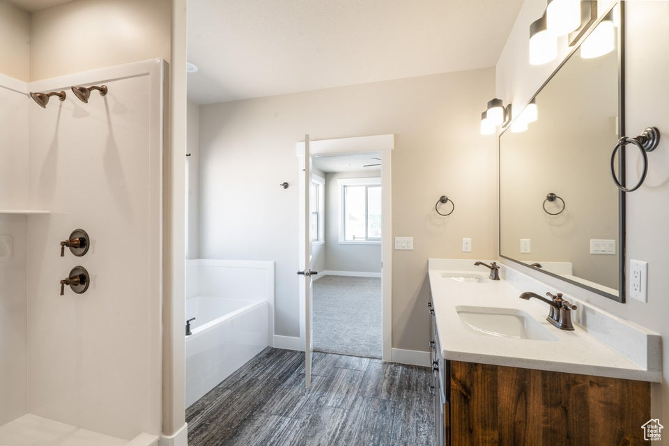 Bathroom with vanity, a tub, and hardwood / wood-style flooring