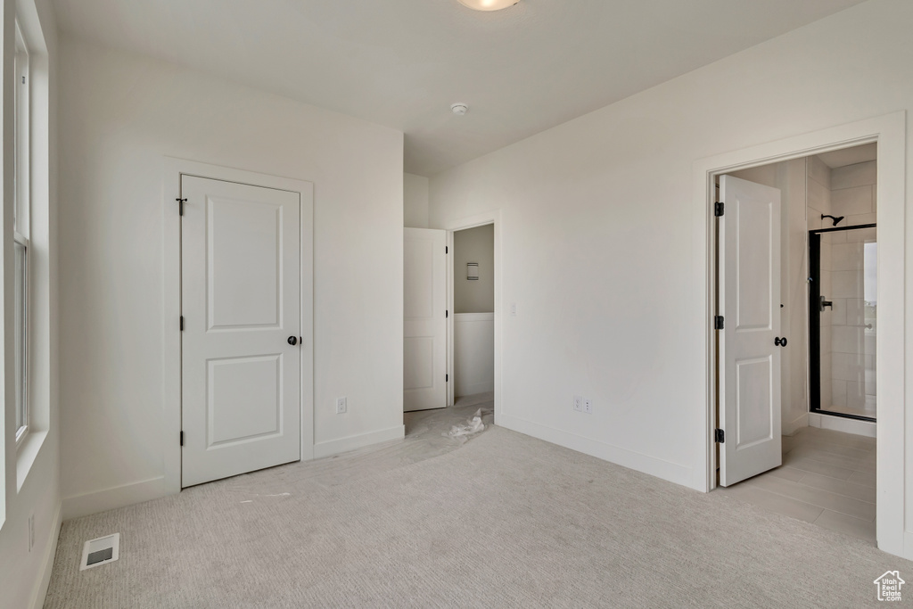 Unfurnished bedroom with visible vents, light carpet, and baseboards
