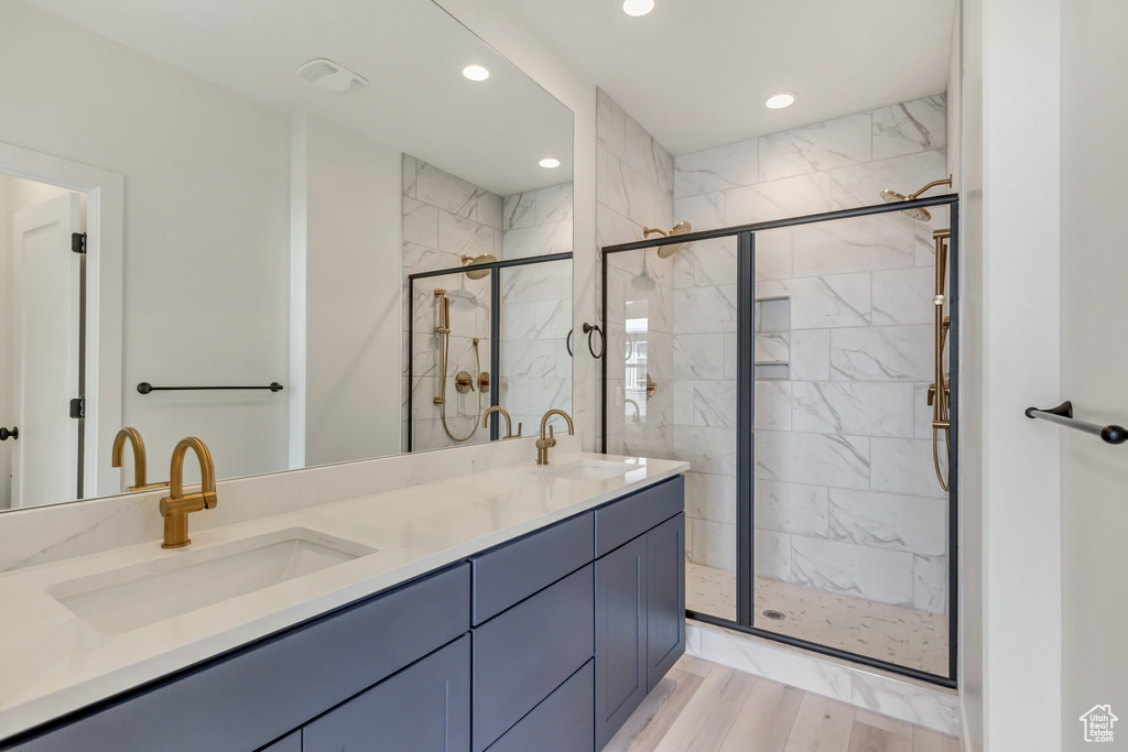 Bathroom featuring vanity, wood-type flooring, and walk in shower