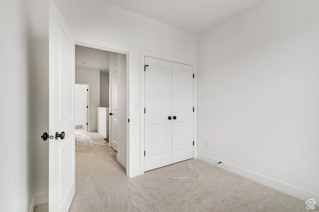 Unfurnished bedroom with baseboards, carpet floors, and a closet