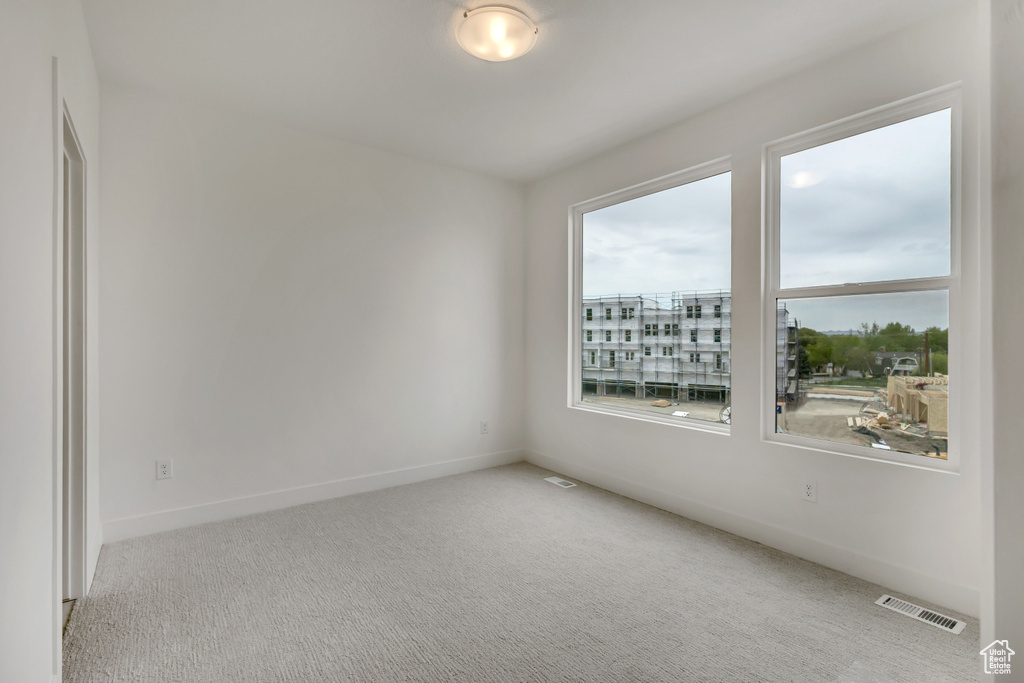 Unfurnished room with baseboards, visible vents, and carpet flooring