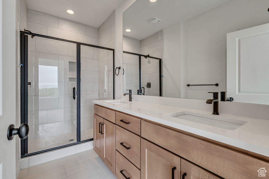 Full bath featuring double vanity, recessed lighting, a stall shower, and a sink