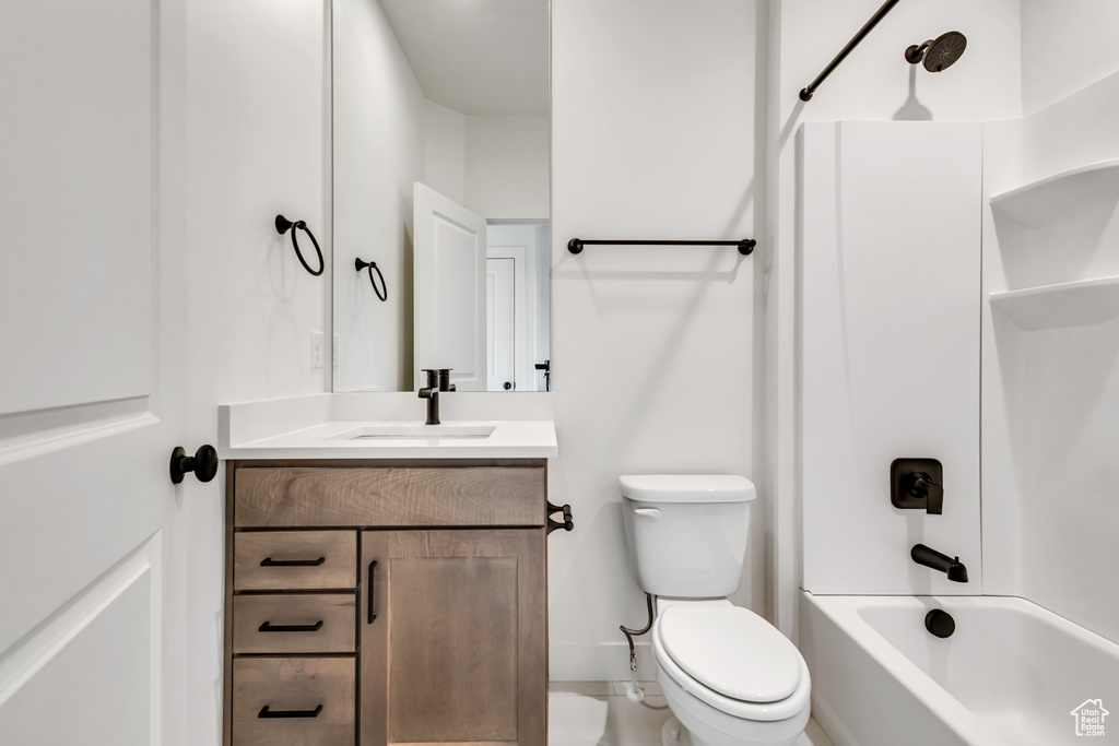 Full bath with toilet, bathing tub / shower combination, vanity, and baseboards