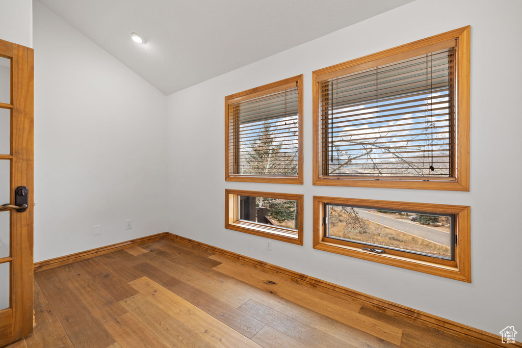 Spare room with vaulted ceiling and hardwood / wood-style flooring