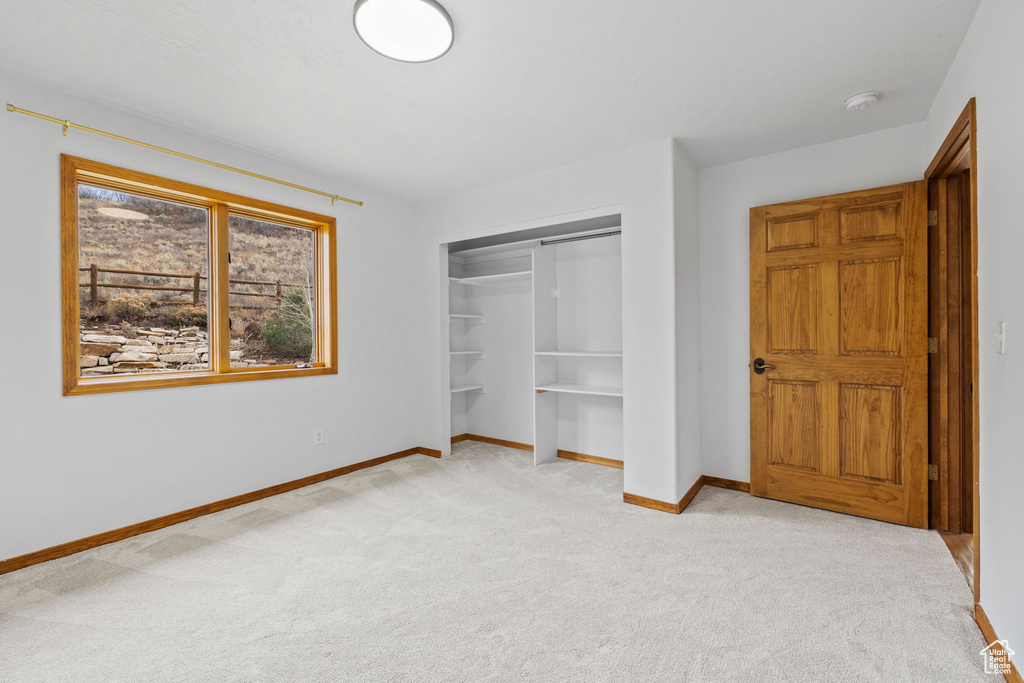 Unfurnished bedroom with a closet and light colored carpet