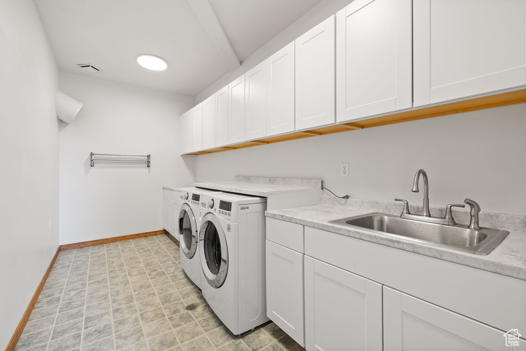 Laundry room with washer and dryer, sink, and cabinets