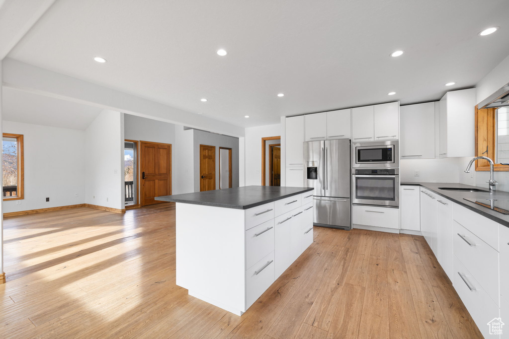 Kitchen featuring appliances with stainless steel finishes, sink, a wealth of natural light, and white cabinetry