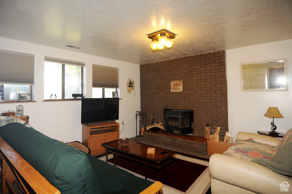 Living room featuring a wood stove and a textured ceiling