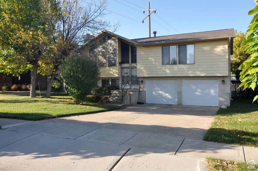 Raised ranch with a front lawn and a garage