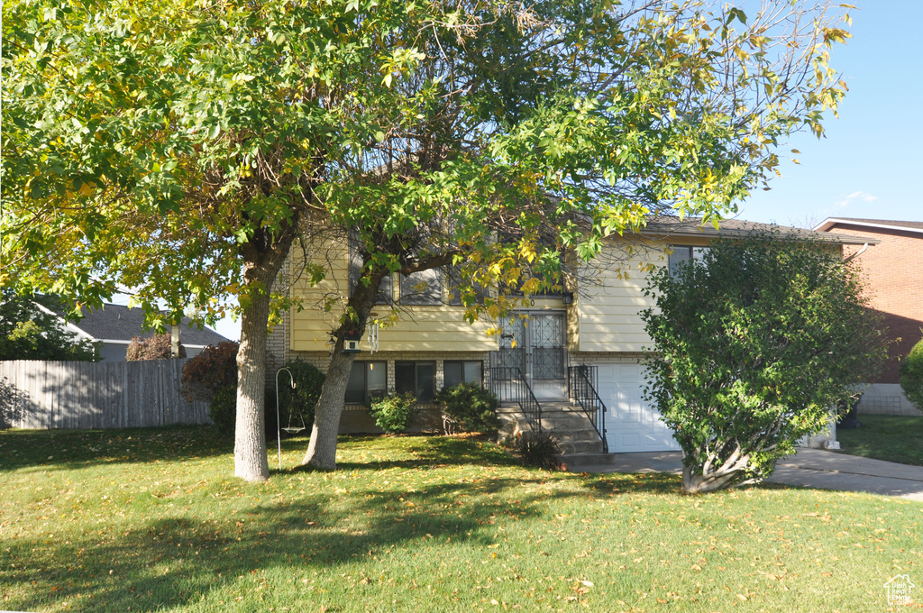 View of front of property with a front lawn and a garage