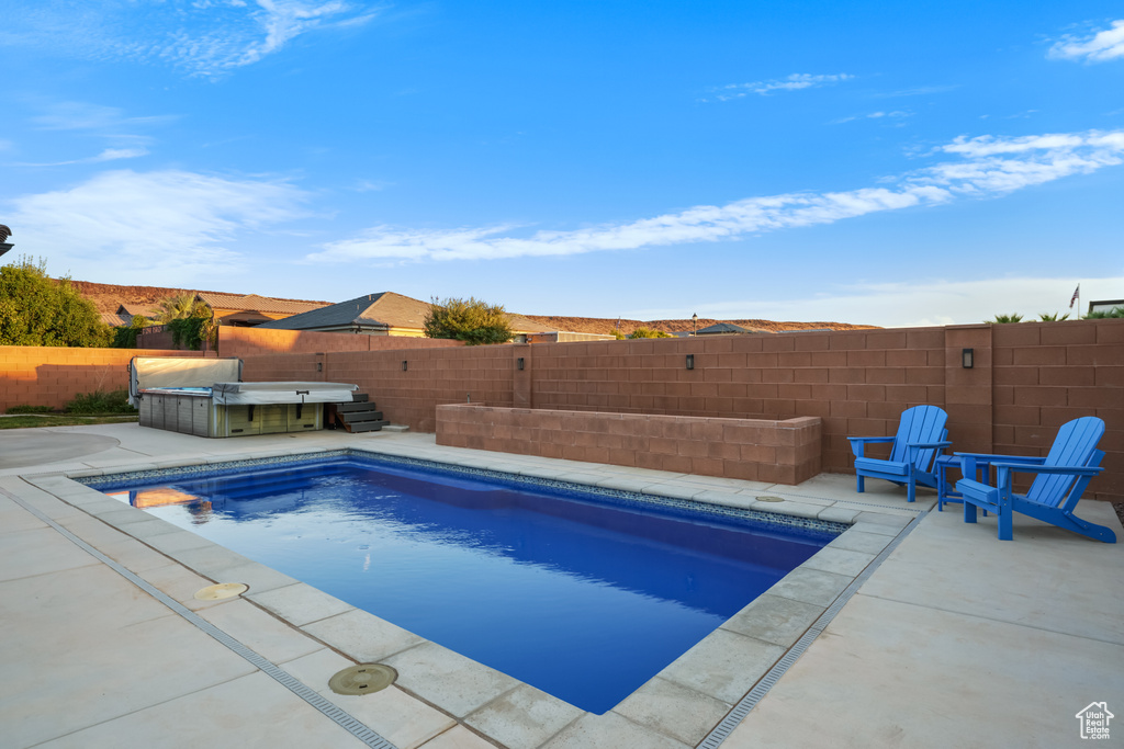 View of pool with a hot tub and a patio