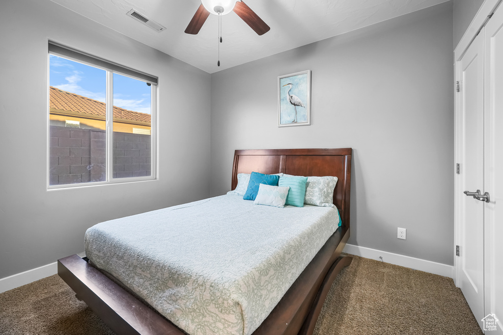 Carpeted bedroom featuring ceiling fan