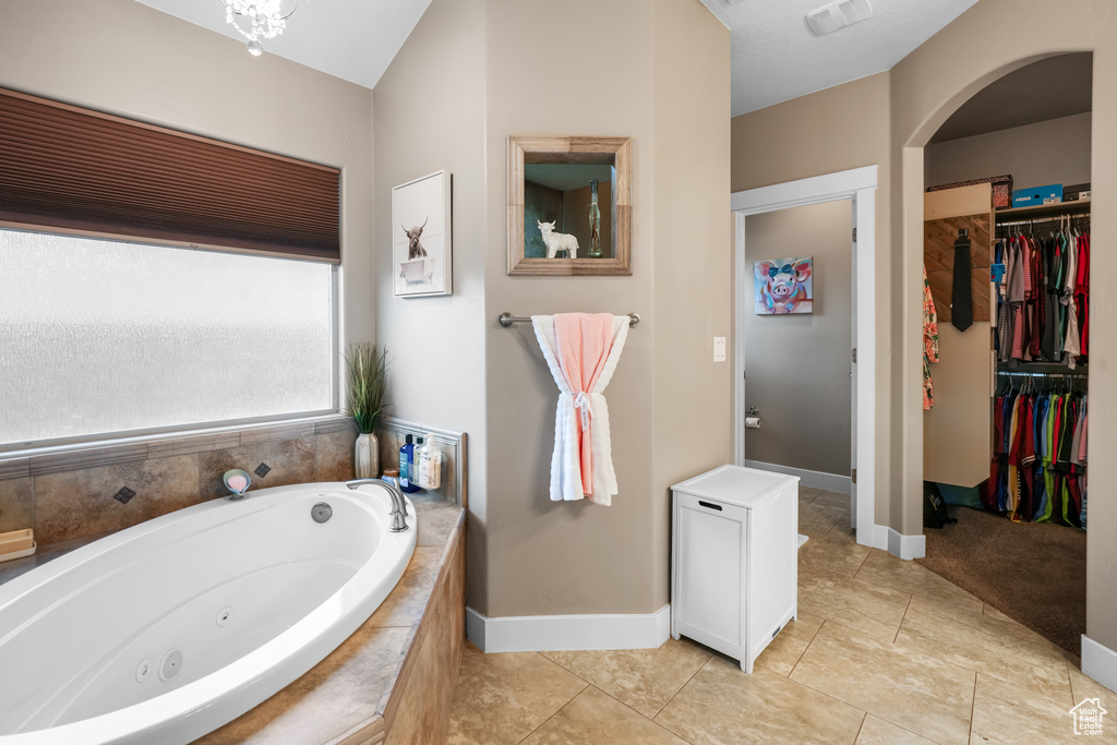 Bathroom featuring tile patterned floors and a relaxing tiled tub