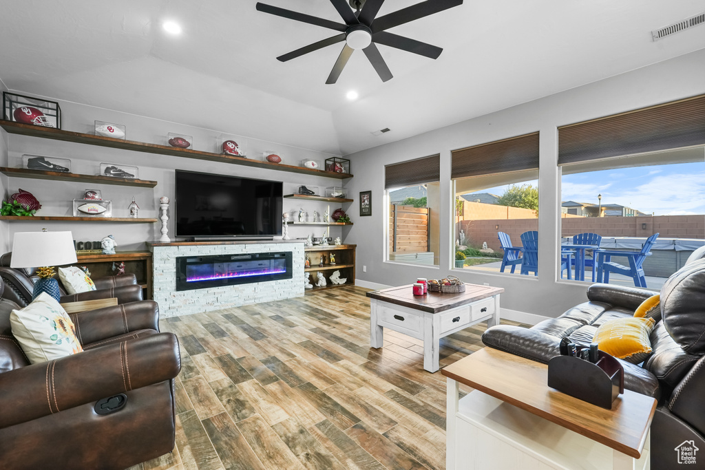 Living room with vaulted ceiling, light hardwood / wood-style floors, and ceiling fan