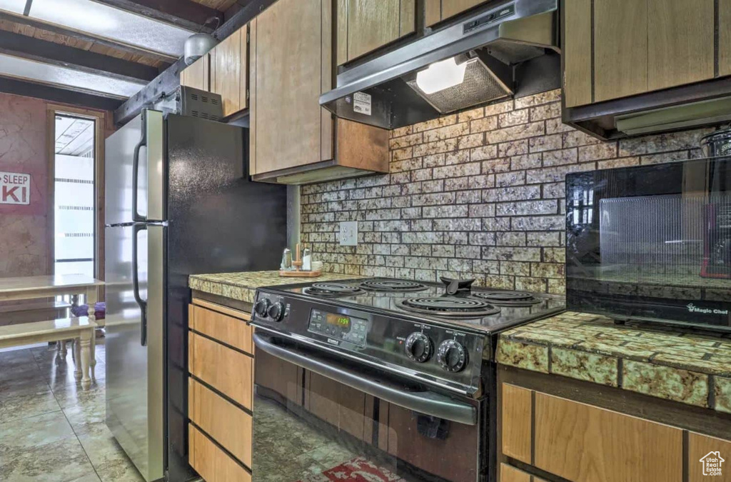 Kitchen featuring black appliances and backsplash