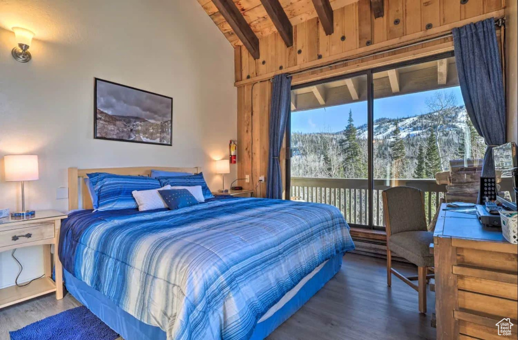 Bedroom with a mountain view, lofted ceiling with beams, and dark hardwood / wood-style flooring