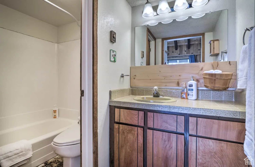 Full bathroom featuring shower / tub combination, vanity, and toilet